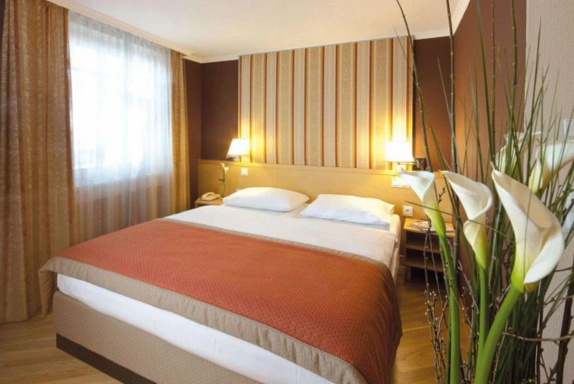 Deluxe Room mit Sitzecke und Ausblick auf den Stadtpark